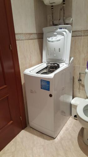 a washing machine sitting in a bathroom next to a toilet at Sonnenküste Andalusien in Torre del Mar