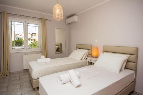 1 dormitorio con 2 camas y ventana en Elena's apartment 3 en Argostoli