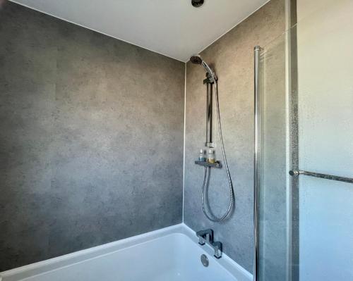 a bathroom with a shower and a white bath tub at The Beach House, Suffolk Coast in Lowestoft
