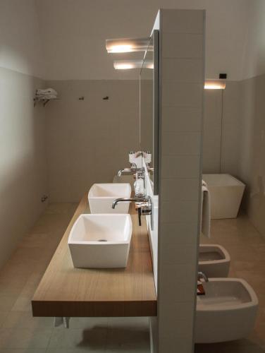 a bathroom with two sinks and two toilets at Hotel Cavour Et Des Officiers in Bard