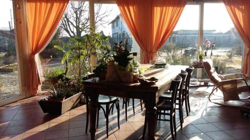 a dining room with a table and some plants at B&B La Castellana in Borgo Lavezzaro