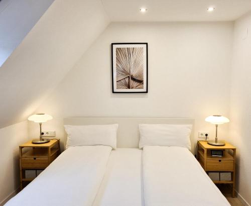 a bedroom with a white bed with two night stands at Mirielle Apartments in Rust