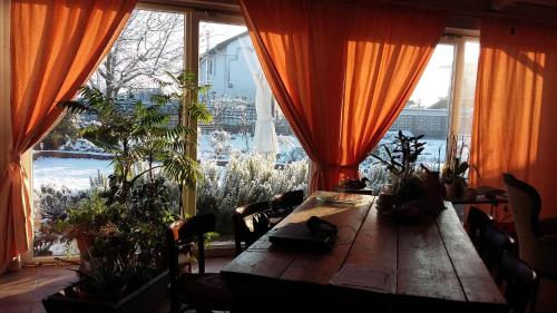 a room with a table with plants and a large window at B&B La Castellana in Borgo Lavezzaro