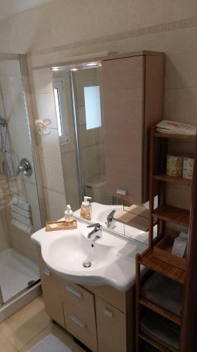 ein Bad mit einem Waschbecken, einer Dusche und einem Spiegel in der Unterkunft Mont Saint Michel in Bari