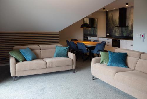 a living room with two couches and a table at Turmalin Apartamenty in Świeradów-Zdrój