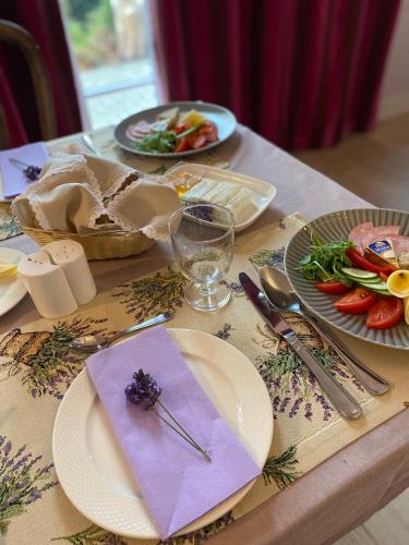 a table with plates of food and a purple napkin at Miód Lawenda in Biardy