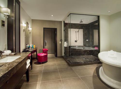 a bathroom with a shower and a sink and a tub at The Cromwell, A Caesars Destination in Las Vegas