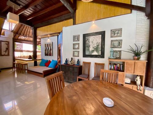 a living room with a wooden table and chairs at Little Tree House in Sanur