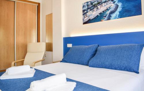 Apartamentos Playamar في إسلا بلانا: غرفة نوم بسرير ازرق وبيض عليها مناشف
