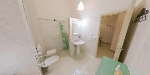 a white bathroom with a toilet and a sink at Stella Maris Marzamemi Apartments in Marzamemi