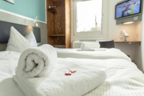 a hotel room with two beds with towels on them at T3 Budget Zwickau in Zwickau