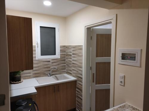 a small bathroom with a sink and a mirror at Gregory Apartments in Tolo