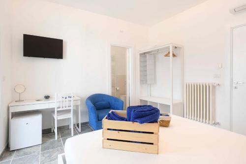 ein weißes Wohnzimmer mit einem blauen Stuhl und einem Schreibtisch in der Unterkunft Lulía bed&breakfast in Otranto