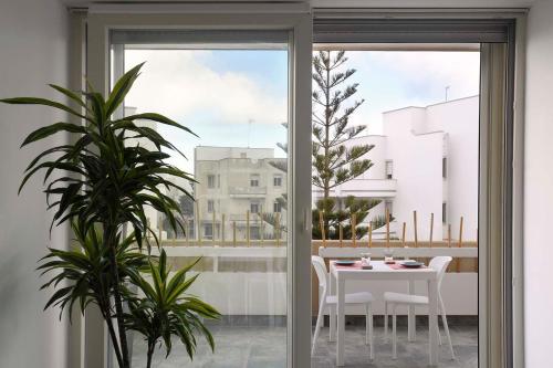 d'une salle à manger avec une table, des chaises et une fenêtre. dans l'établissement Lulía bed&breakfast, à Otrante