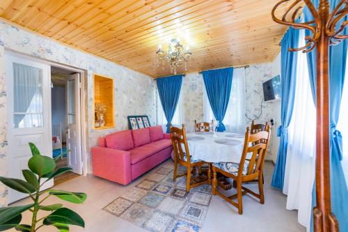 salon z różową kanapą i stołem w obiekcie Savanna Guest House w mieście Dedoplis Tskaro