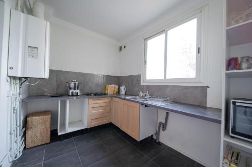 a kitchen with white cabinets and a window at LE VIEUX MOULIN in Aureilhan