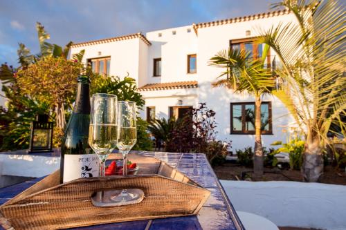 een fles wijn en twee glazen op een tafel bij Villa con piscina privada, vistas y jardín in Guía de Isora