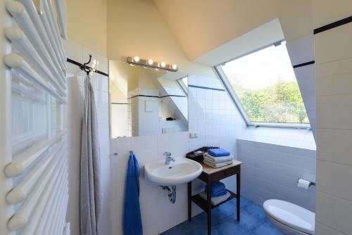 a bathroom with a sink and a toilet and a window at Ferienwohnung 8 für 4 Personen Seeblick in Neuenkirchen