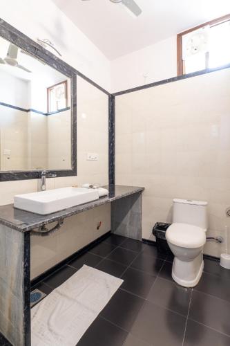 a bathroom with a white toilet and a sink at Bhola Bhawan Bed and Breakfast in Jaipur