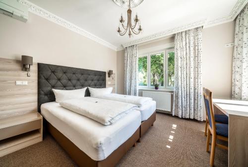 a bedroom with a bed and a desk and a desk at Hotel Villa am Waldschlösschen in Dresden