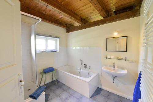 a bathroom with a tub and a sink at Ferienhaus Remise 6 Personen mit Terrasse in Neuenkirchen