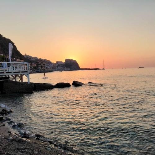 a sunset over the water with a pier at Al Quindici Scilla in Scilla