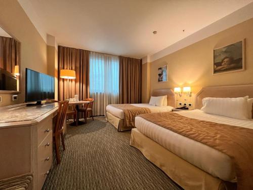 a hotel room with two beds and a flat screen tv at Holiday Inn Naples by IHG in Naples