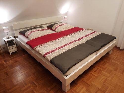 a large bed in a room with a wooden floor at Ferienwohnung -Main- Ruheplatz am Wasser in Langenprozelten