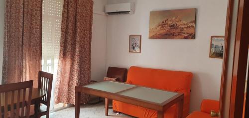 a living room with an orange chair and a table at Playa La Caleta La Viña Cadiz PLAZA GARAJE GRATIS in Cádiz