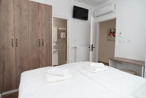 a bedroom with a large white bed with wooden cabinets at ZIMMER KAJ in Zabok
