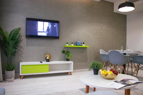 a living room with a tv on a wall at Citadines Al Ghubrah Muscat in Muscat