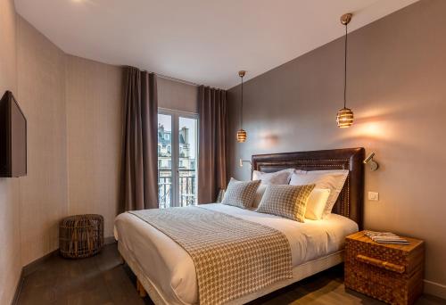 une chambre avec un grand lit et une fenêtre dans l'établissement BE YOU LUXURY APART'HÔTEL Paris, à Paris