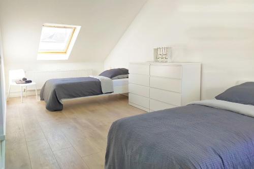 a bedroom with two beds and a white dresser at Holiday Apartments Brachttal in Hellstein