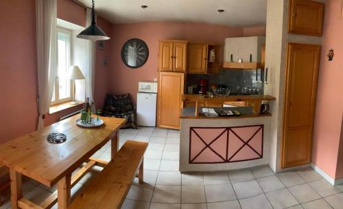 une cuisine avec une table en bois et une salle à manger dans l'établissement Voie Verte, à Cornimont