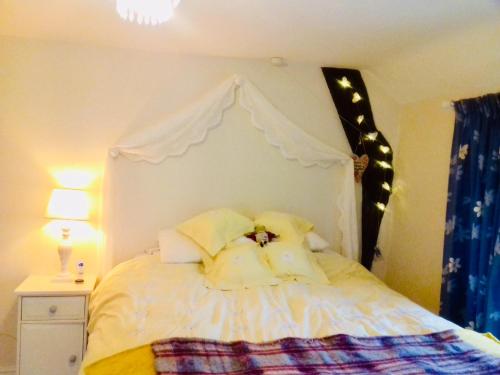 a bedroom with a white bed with a canopy at Virginia Cottage in Bulwick