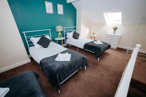 two beds in a room with blue walls at Highfield Lodge in Sheffield