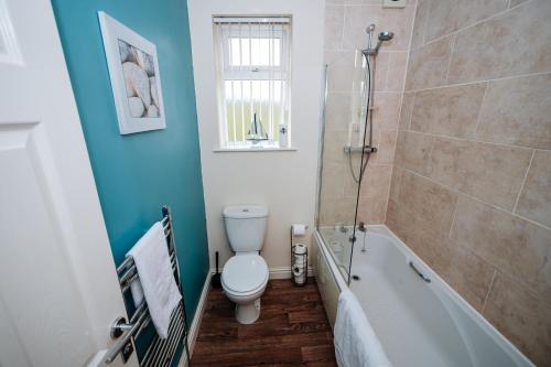 a bathroom with a toilet and a bath tub at Highfield Lodge in Sheffield