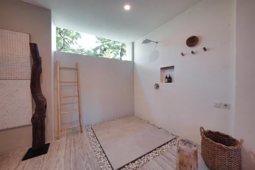 a room with a ladder and a room with white walls at El Tropico Boutique Hotel in Kuta Lombok