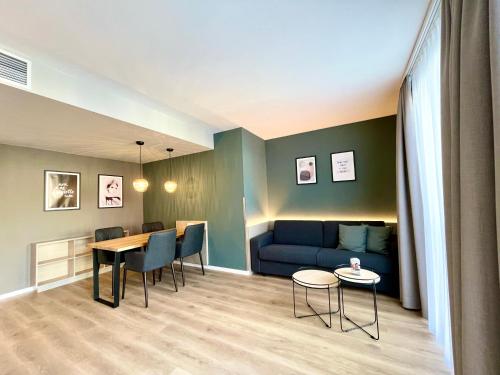 a living room with a blue couch and a table at zeitwohnhaus SUITE-HOTEL & SERVICED APARTMENTS in Erlangen