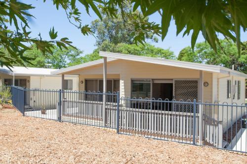 a house with a blue fence in front of it at Discovery Parks - Swan Valley in Caversham