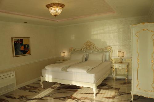 a bedroom with a white bed and a chandelier at Art Complex Anel in Sozopol