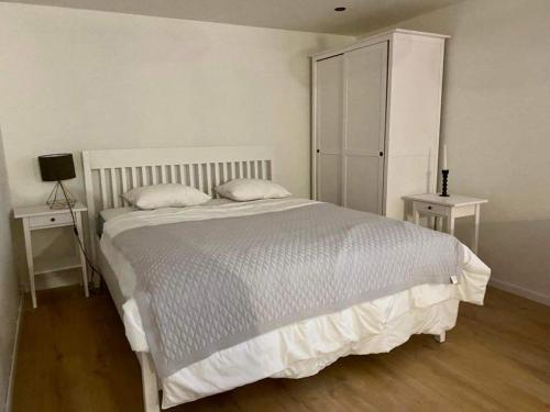 a bedroom with a white bed and two night stands at BRICK Apartment in Žilina