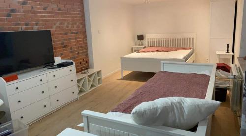 a bedroom with a bed and a dresser with a television at BRICK Apartment in Žilina