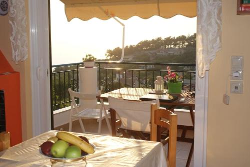 een balkon met een tafel en een fruitschaal. bij Alexandra's Apartment in Kalamitsi