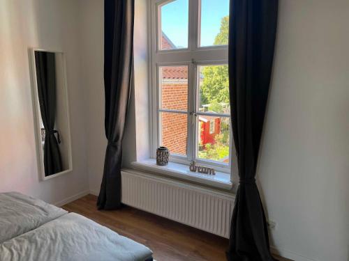 a bedroom with a window with black curtains at Ferienwohnung Hafensicht 25507 in Weener