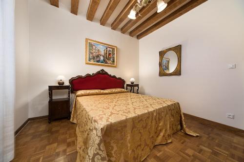 a bedroom with a large bed with a red bedspread at at 2 minutes from San Marco square in Venice