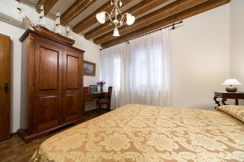a bedroom with a large bed and a wooden cabinet at at 2 minutes from San Marco square in Venice