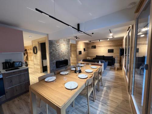 - un salon avec une grande table et un canapé dans l'établissement BOREAL Bel appartement village et pistes, à La Clusaz