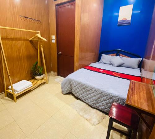 a bedroom with a bed and a blue wall at Hue Happy Homestay in Hue