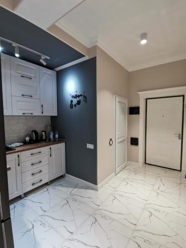 a kitchen with white cabinets and a blue wall at Sumqayıt bulvarı in Sumqayyt